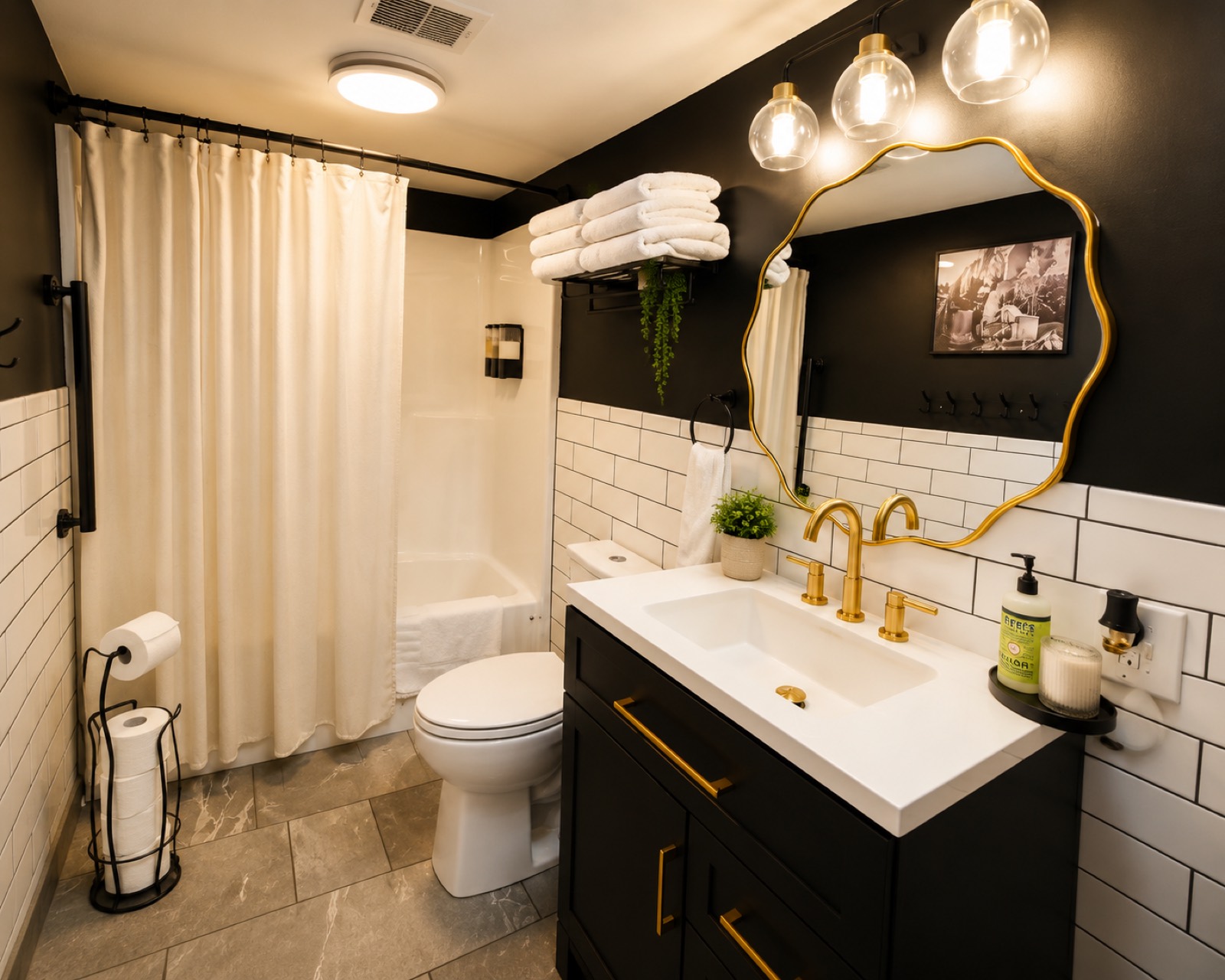 Bathroom vanity with gold faucet and scalloped mirror