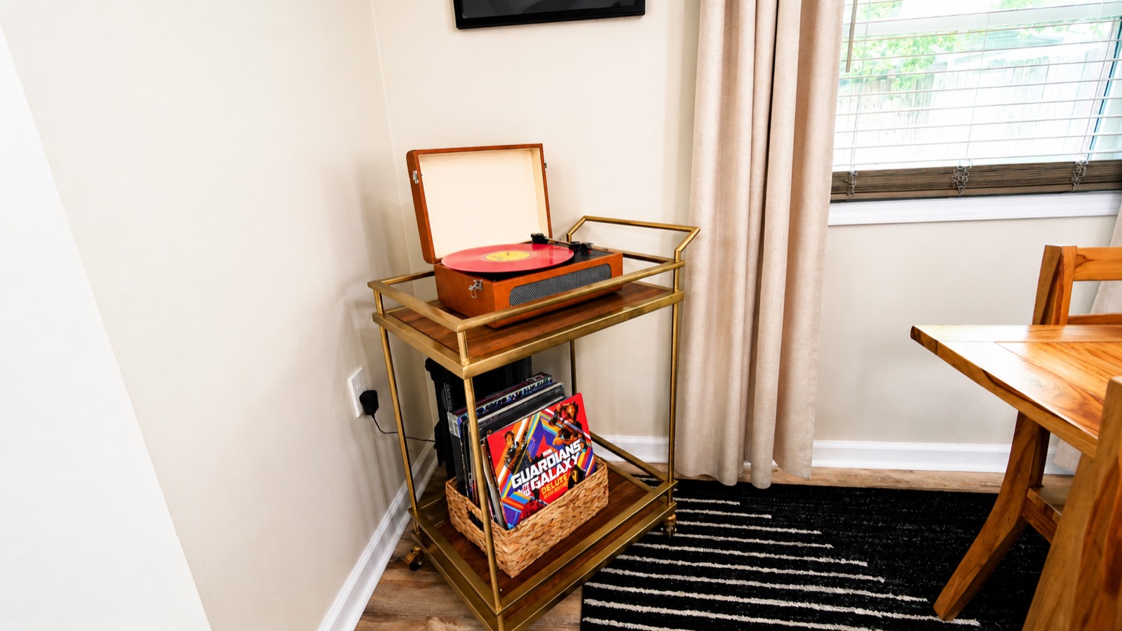 Record player and vinyl collection on a gold bar cart