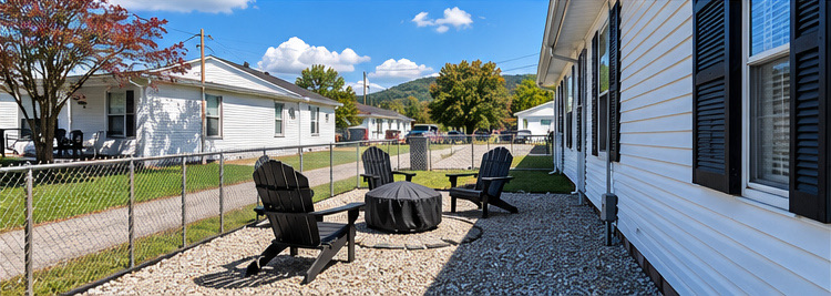 Fenced gravel patio with Adirondack chairs