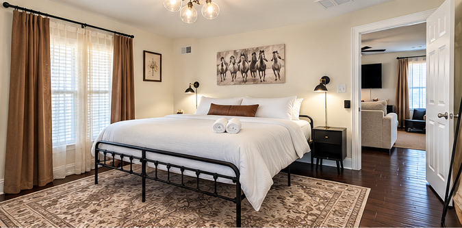Bedroom with a black iron bed and white linens